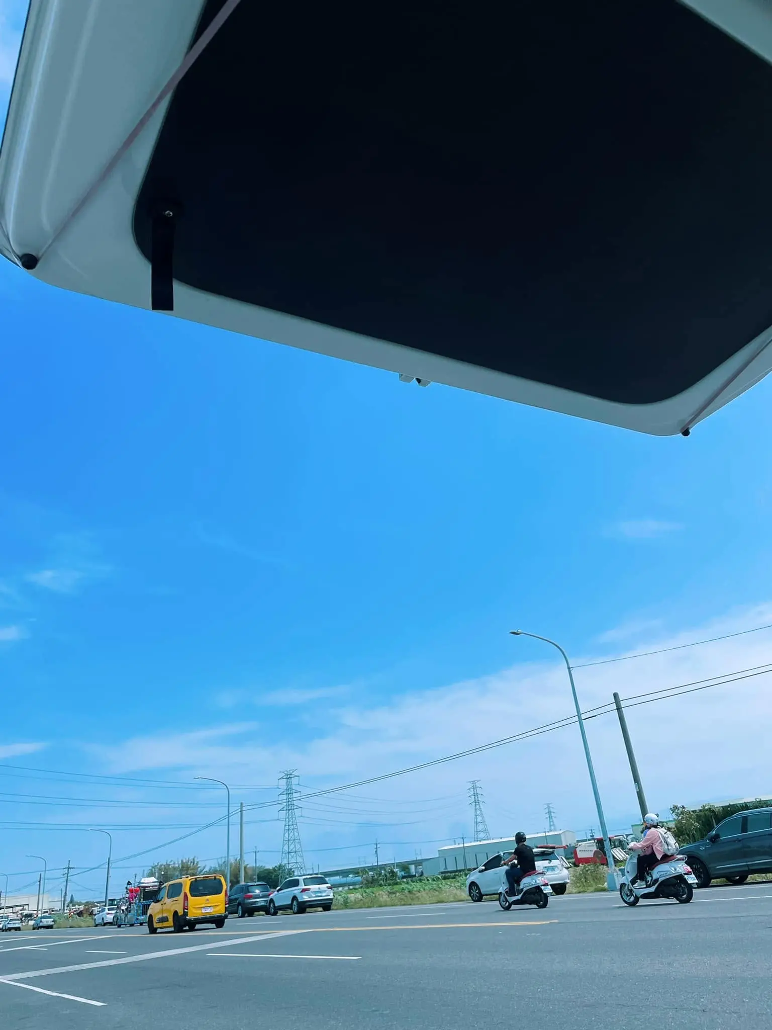 從車尾門下望出去的藍天與進香路上的馬路