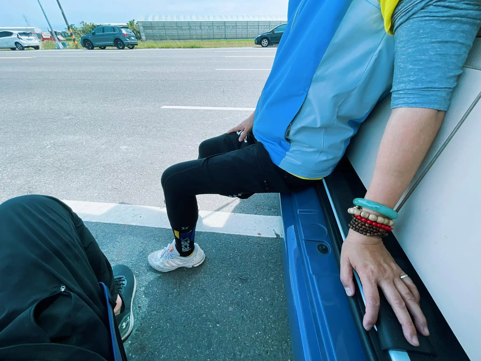 進香路邊坐在車尾休息，手上戴著佛珠手環